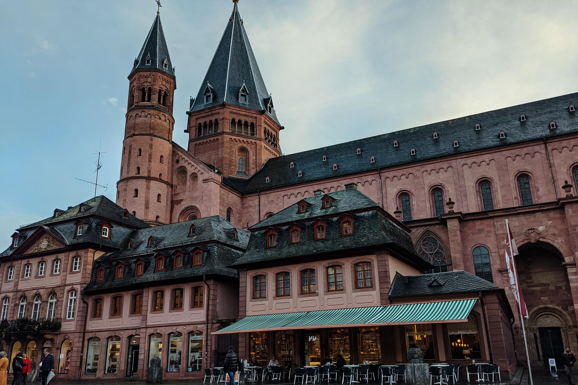 Mächtiger Sandsteindom mit Türmen hinter historischen Fachwerkhäusern