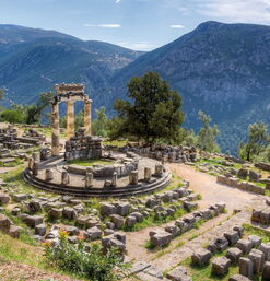 Ruinen des Tholos von Delphi mit umliegender Berglandschaft und antiken Steinen