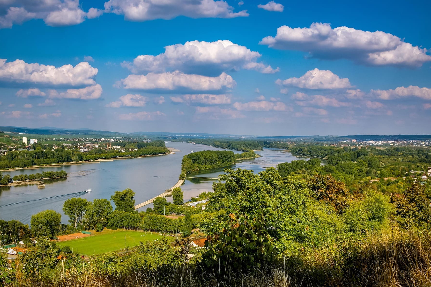 Blick von Hügeln auf breite Rheinschleife mit Feldern und Wäldern