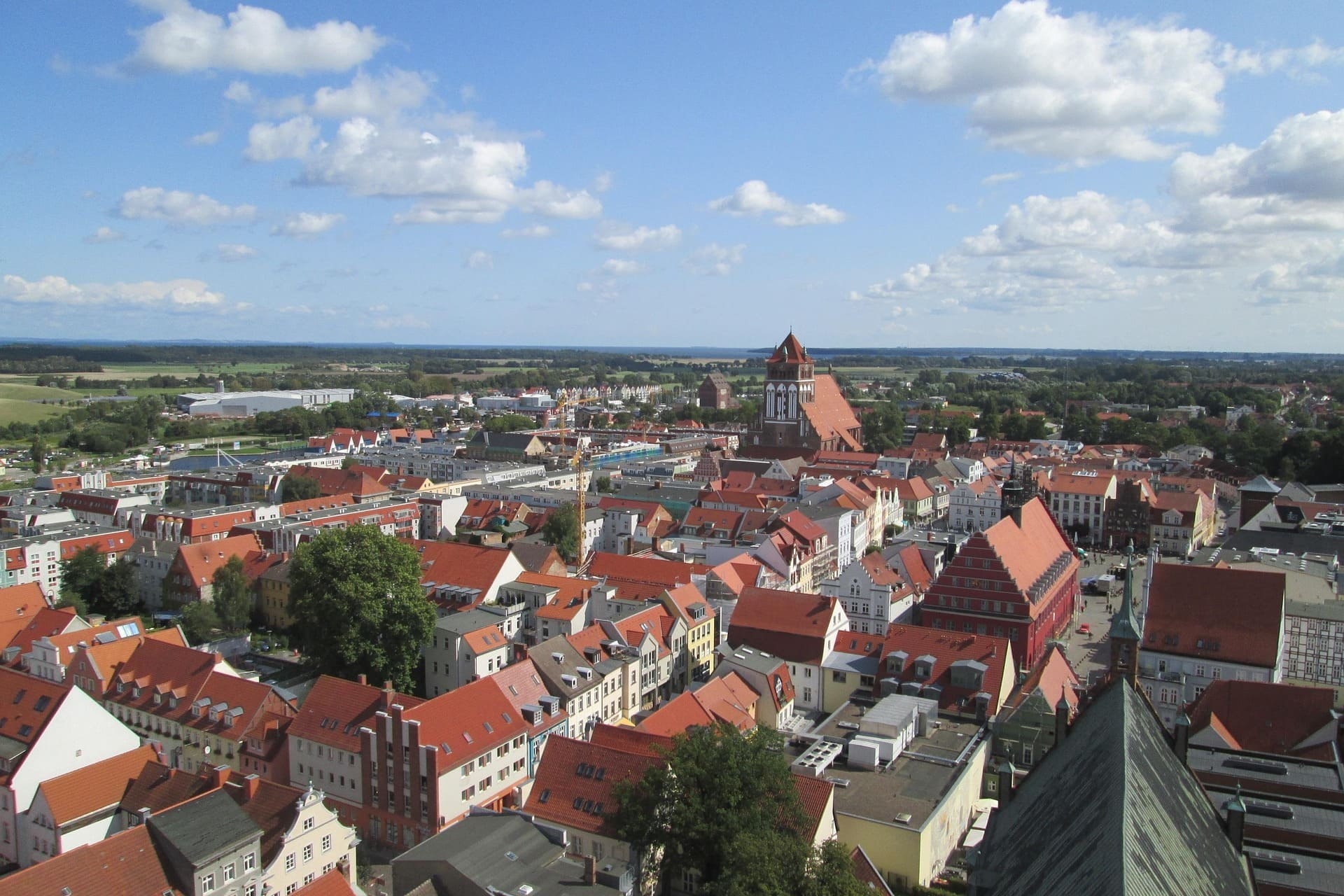 Blick über Stadt mit roten Ziegeldächern und großer Backsteinkirche