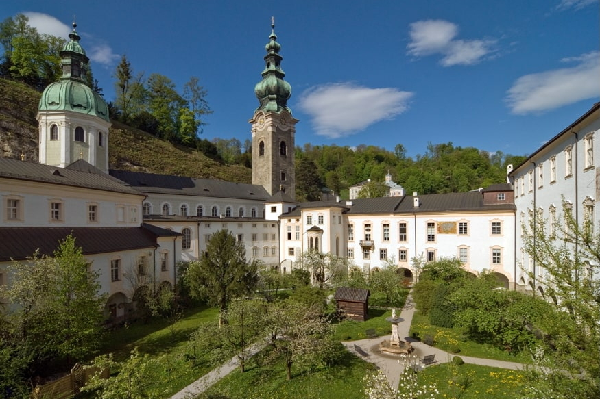 Barocke Klosteranlage mit Türmen und grünem Innenhofgarten