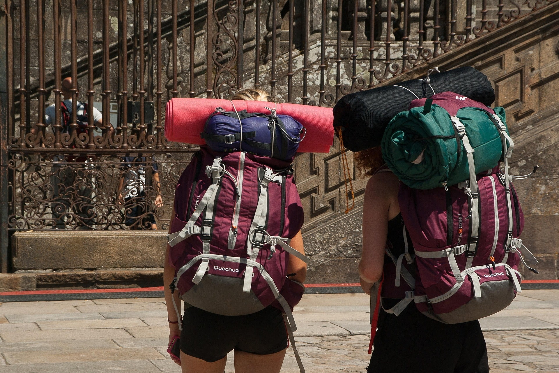 Zwei Personen mit großen Rucksäcken und Isomatten