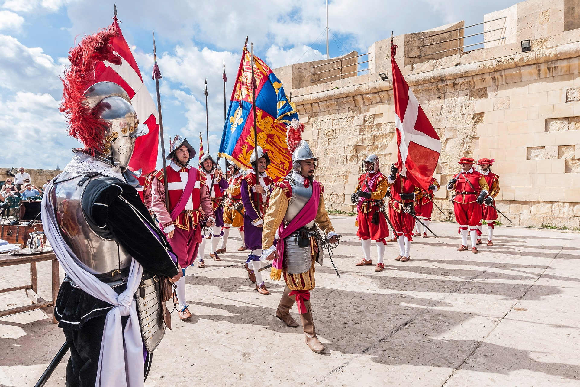Historische Parade in bunten Uniformen vor der Festungsmauer von Valletta
