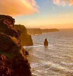 Steilklippen an Irlands Westküste mit goldener Abendstimmung über dem Atlantik
