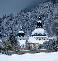 Verschneite Klosterkuppel vor dichtem Nadelwald
