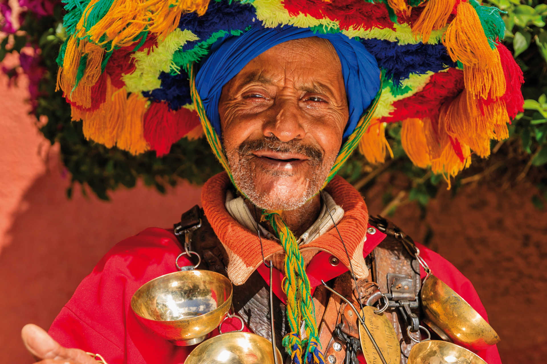 Marokkanischer Wasserverkäufer mit buntem Gewand, Glöckchen und traditionellem Hut
