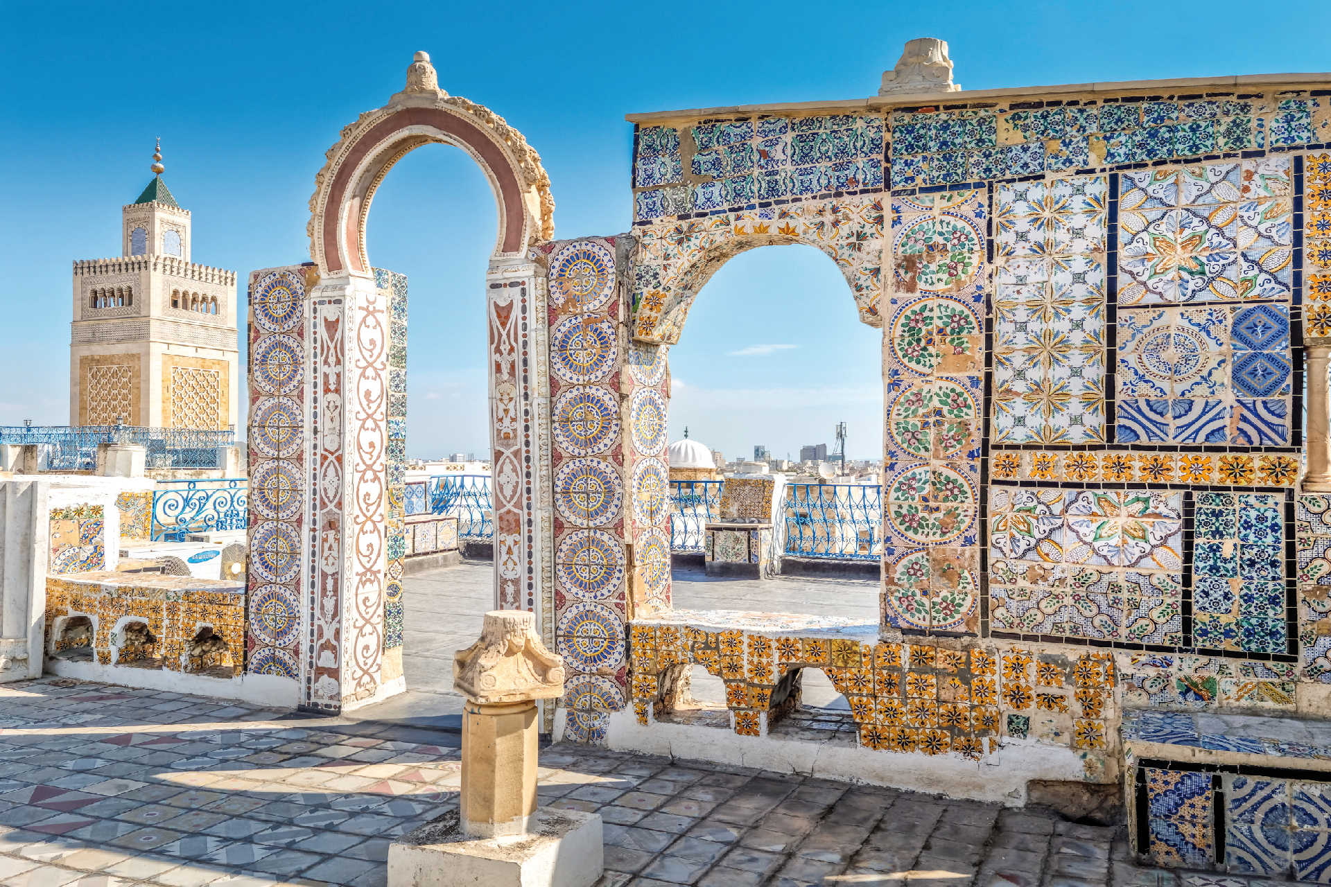Verzierte Mauern und Minarett in der Altstadt von Tunis bei klarem Himmel