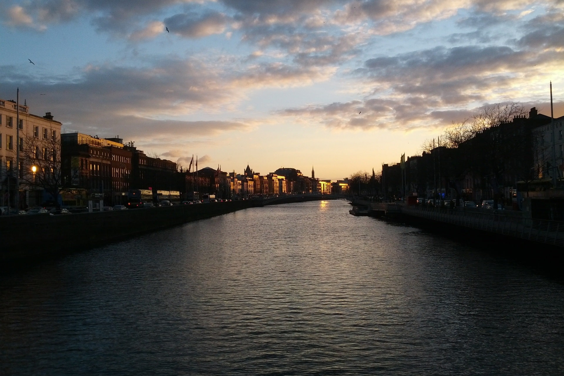 Städtischer Fluss mit Uferpromenade im Abendlicht