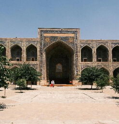 Prunkvolle Fassade mit Mosaiken und Innenhof mit Bäumen