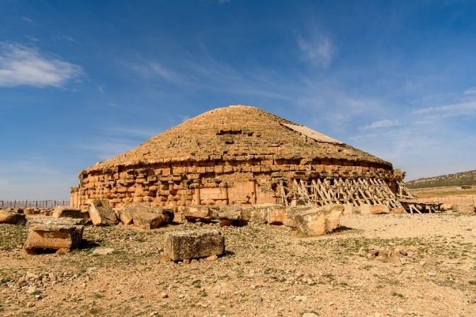 Rundes antikes Grabmal aus Stein mit Kuppeldach in weiter Landschaft