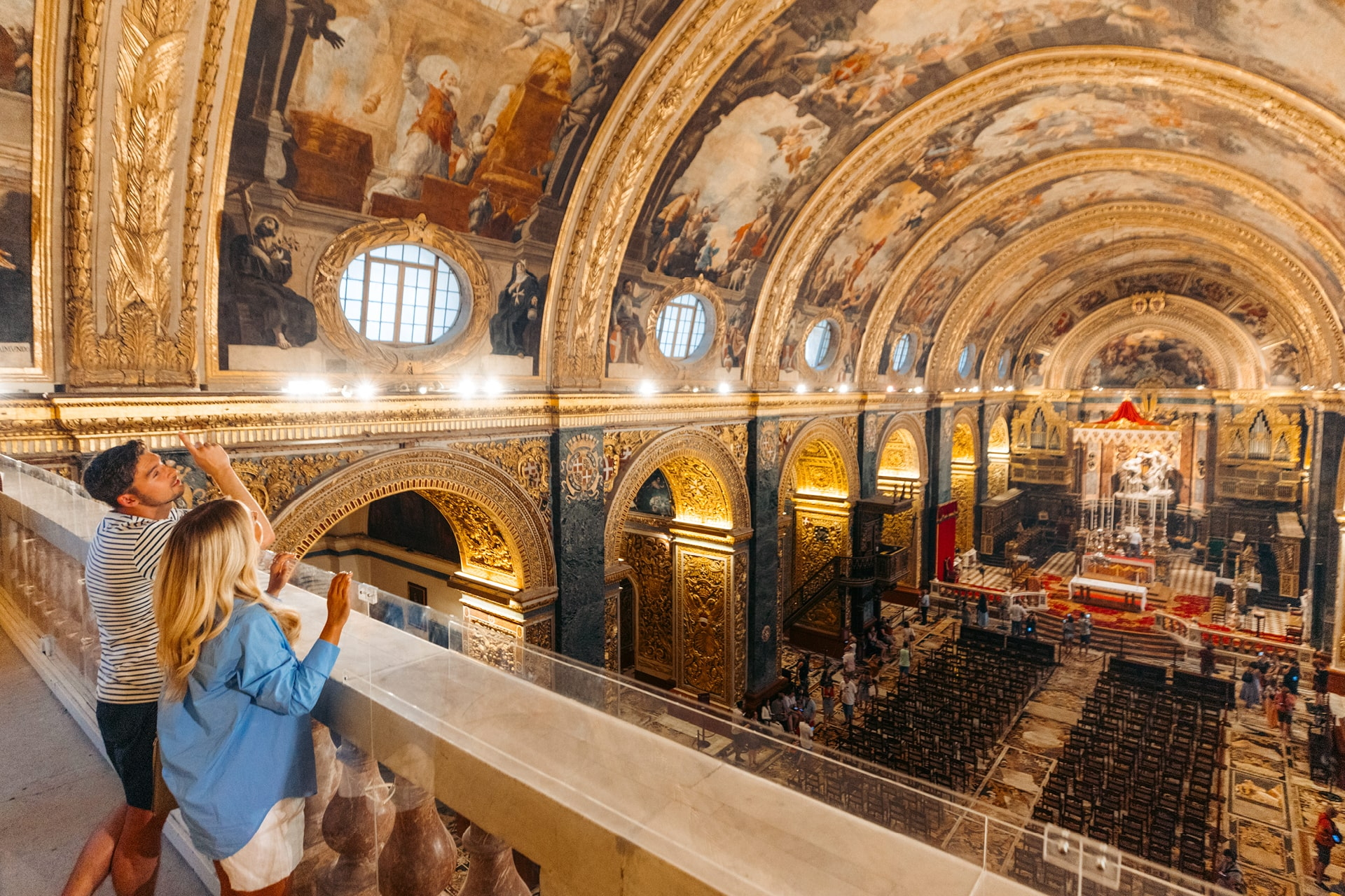 Besucher blicken von Empore auf reich geschmücktes Kirchenschiff mit Gewölbe