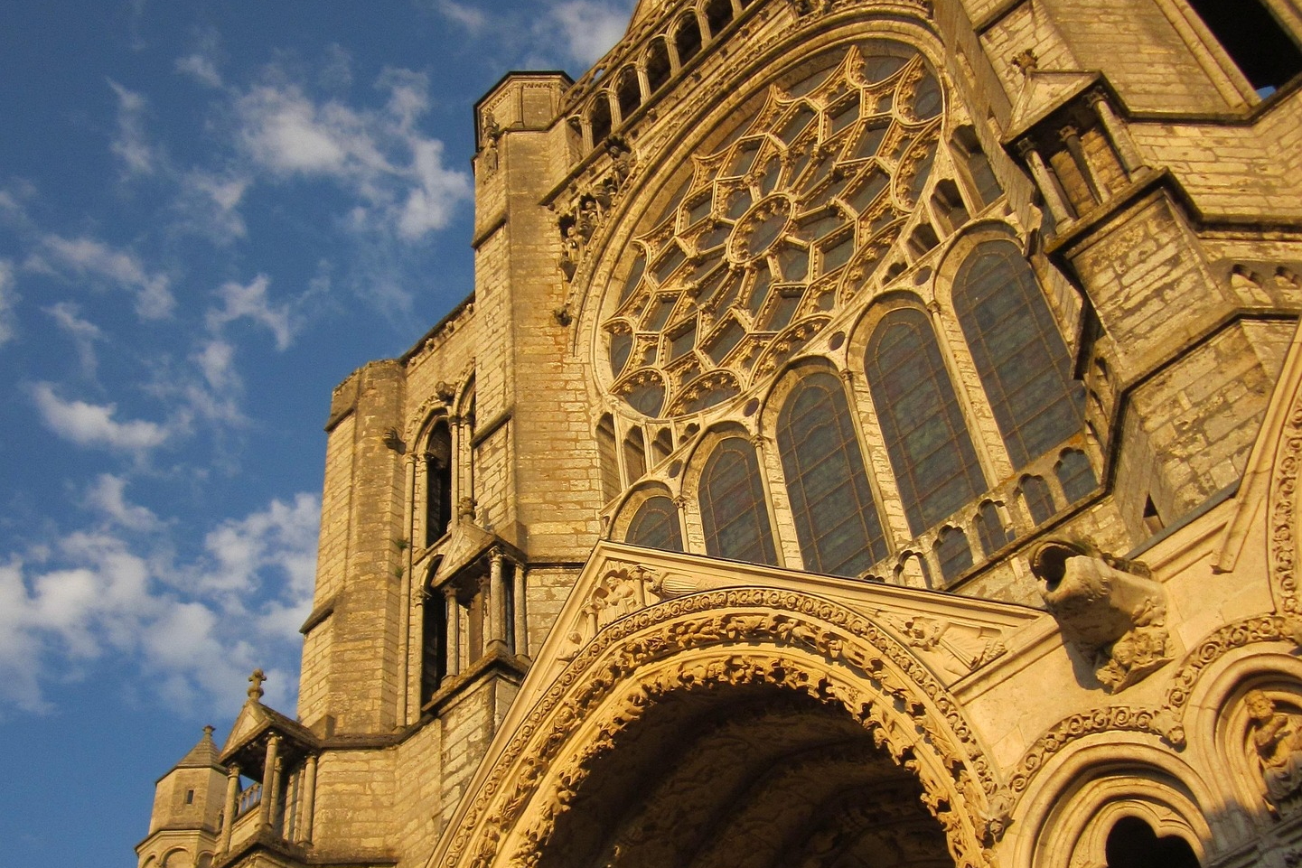 Westfassade mit Rosettenfenster und Figurenportal im Licht der Abendsonne