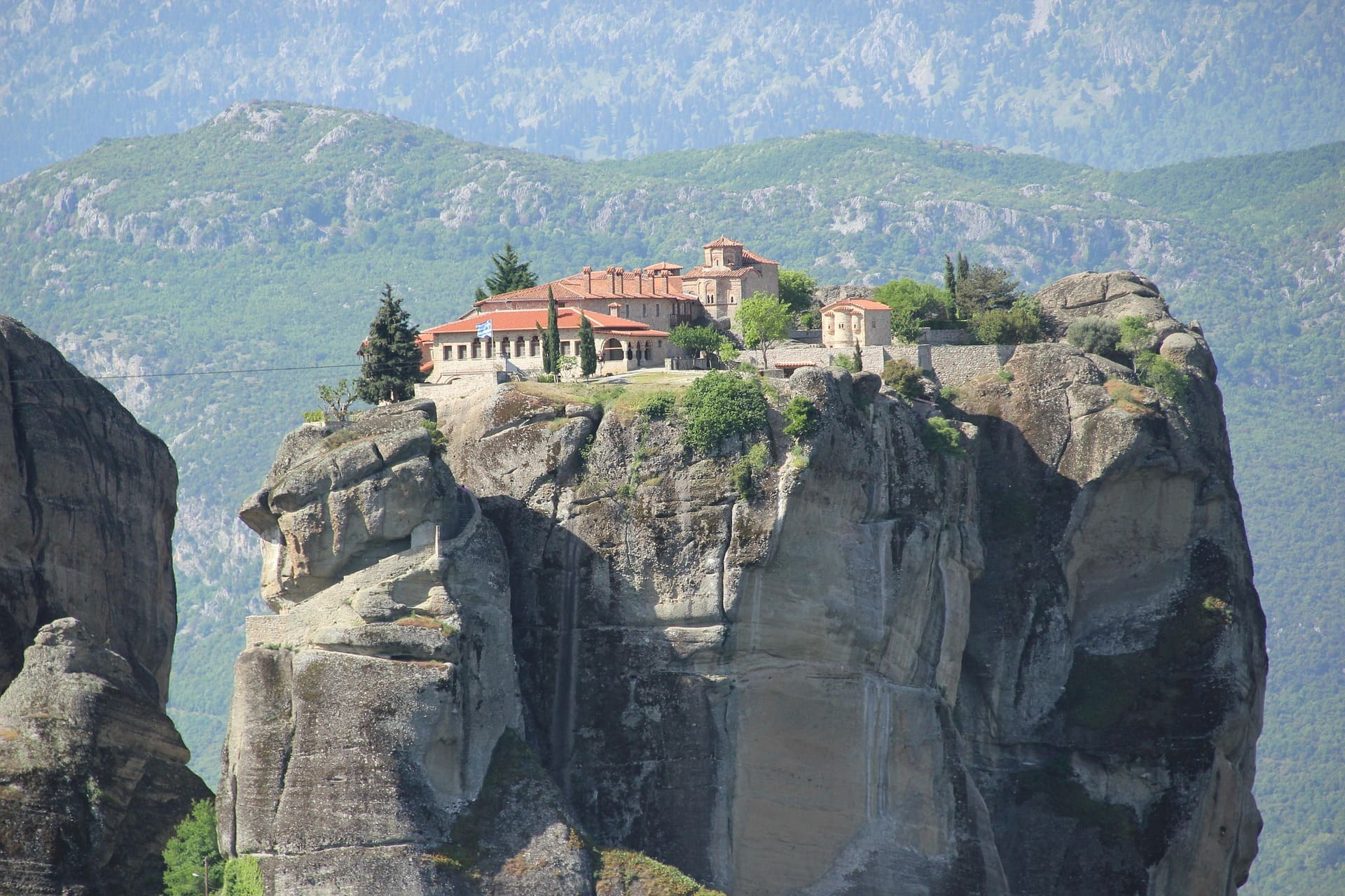 Meteora-Klosteranlage auf steilem Felsen über grüner Landschaft