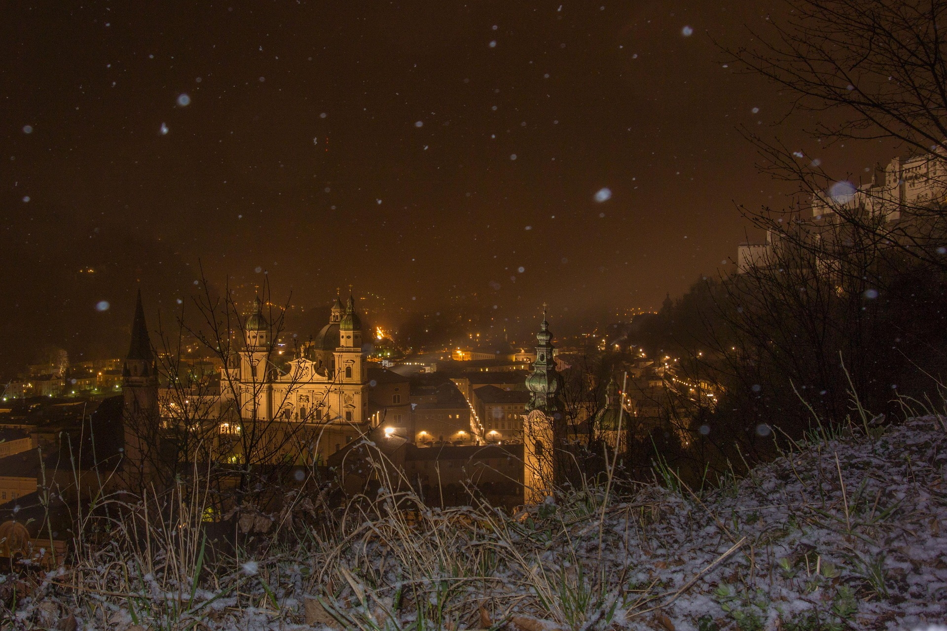 Beleuchtete Altstadt mit Dom und Schneeflocken in der Nacht