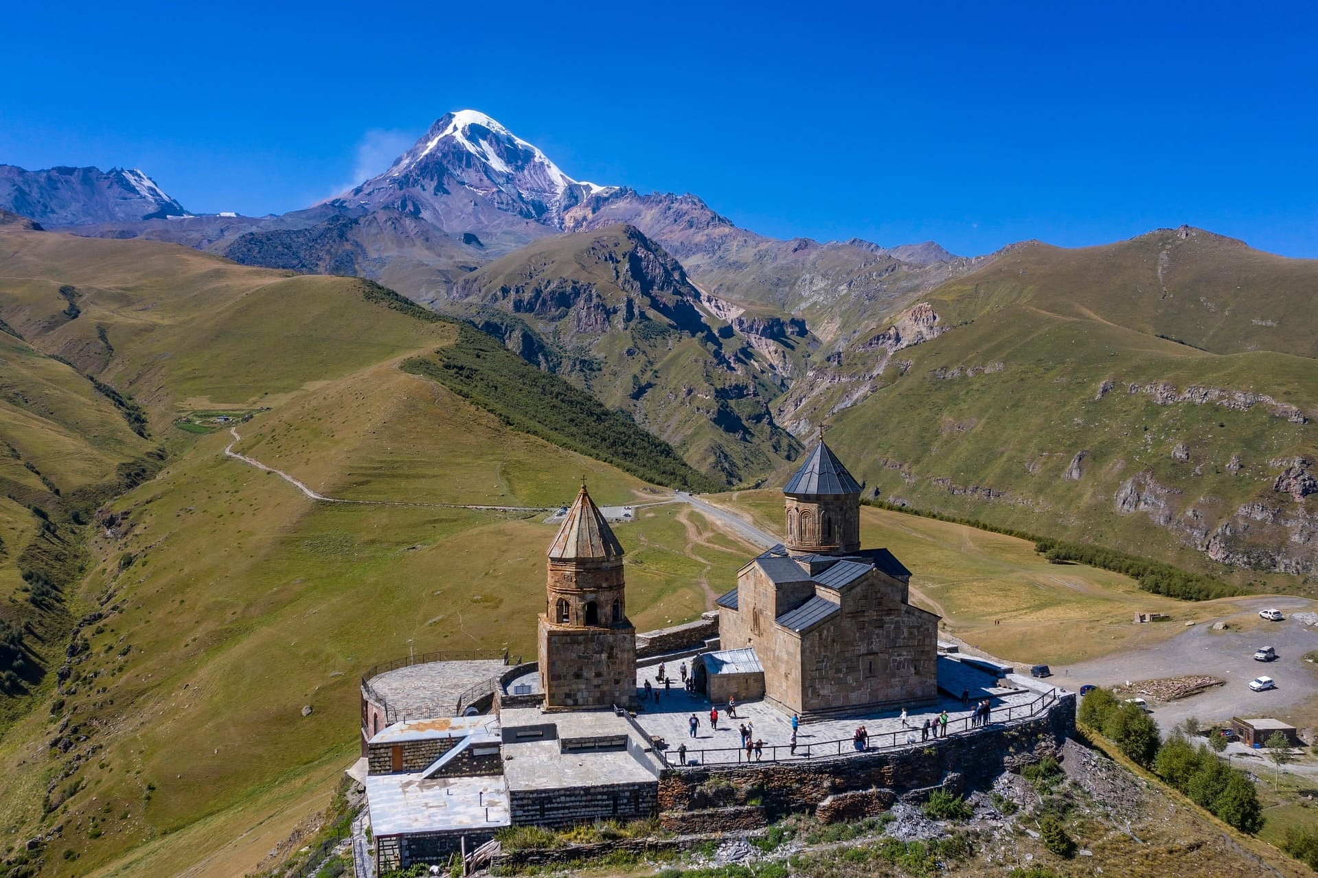 Steinkirche auf Anhöhe mit Blick auf schneebedeckten Gipfel