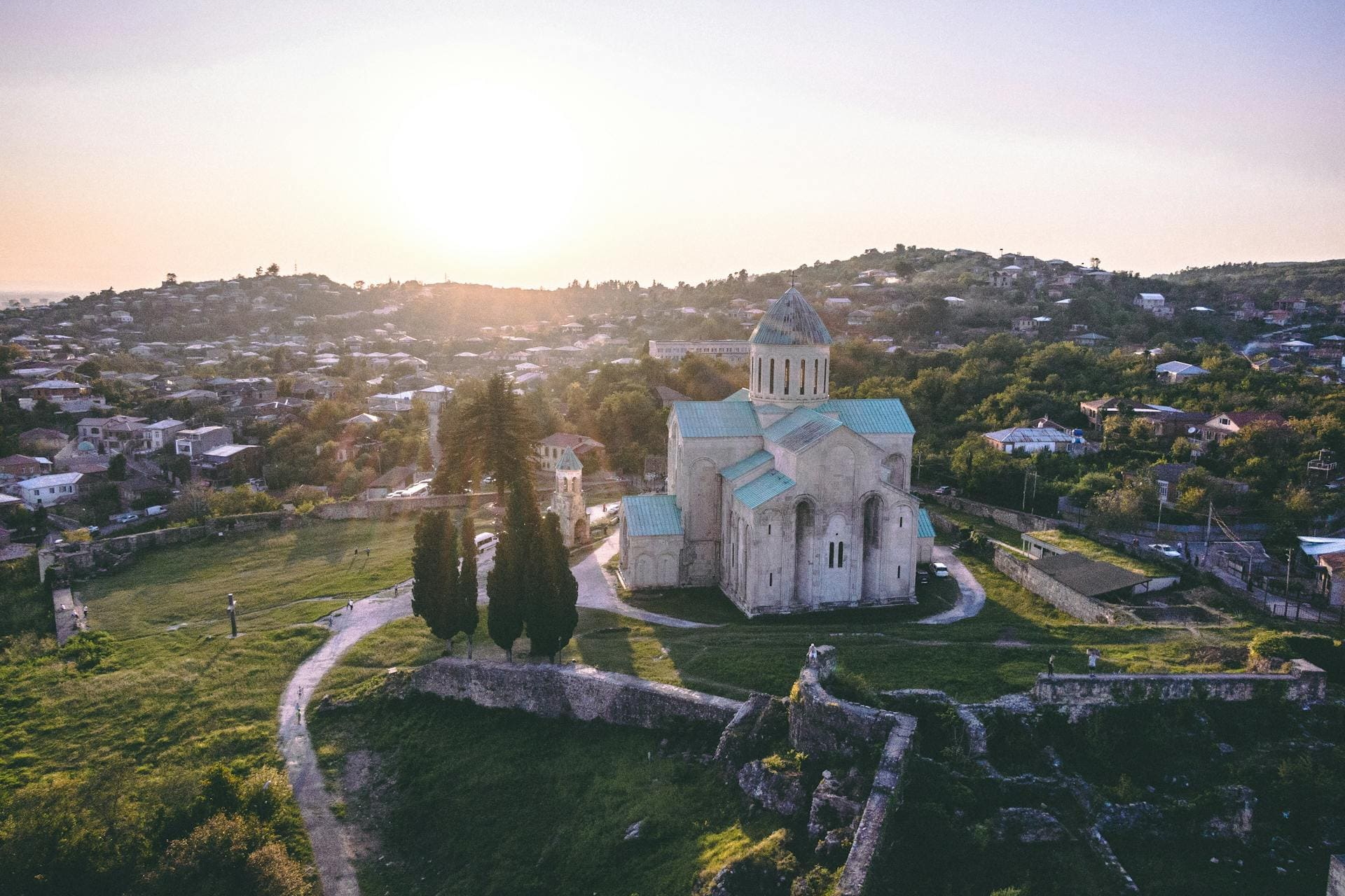 Steinkirche mit grünem Dach auf Hügel bei Sonnenuntergang