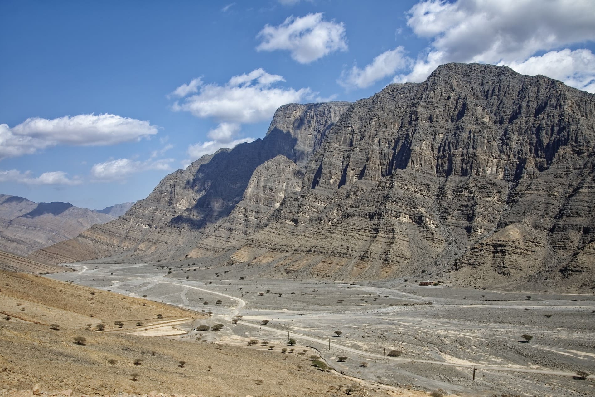 Karges Gebirge mit steilen Felswänden und trockenem Talboden