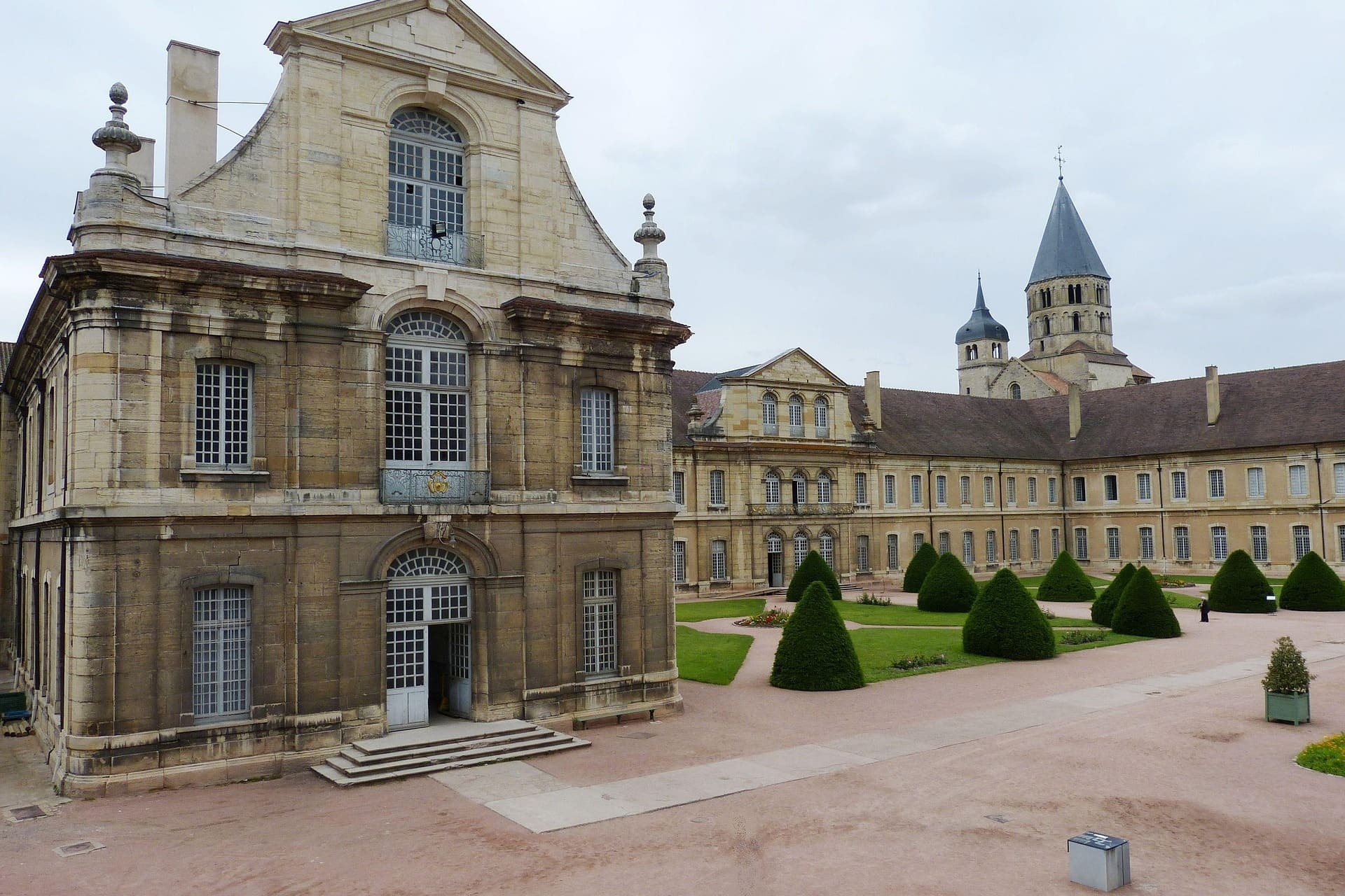 Historisches Klostergebäude mit Türmen und gepflegtem Innenhofgarten