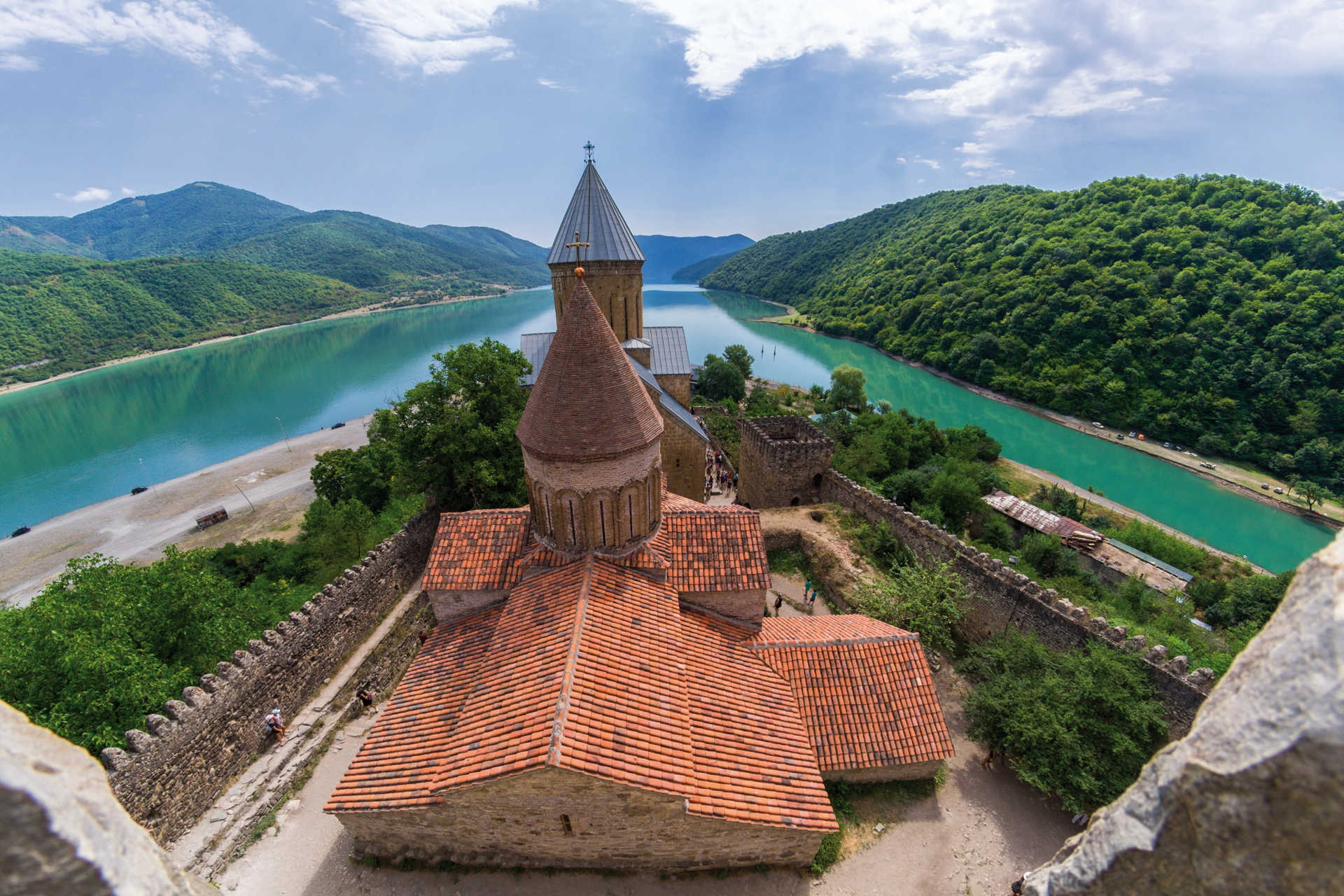 Kirche der Festung Ananuri mit Blick auf türkisblauen Fluss und bewaldete Hügel