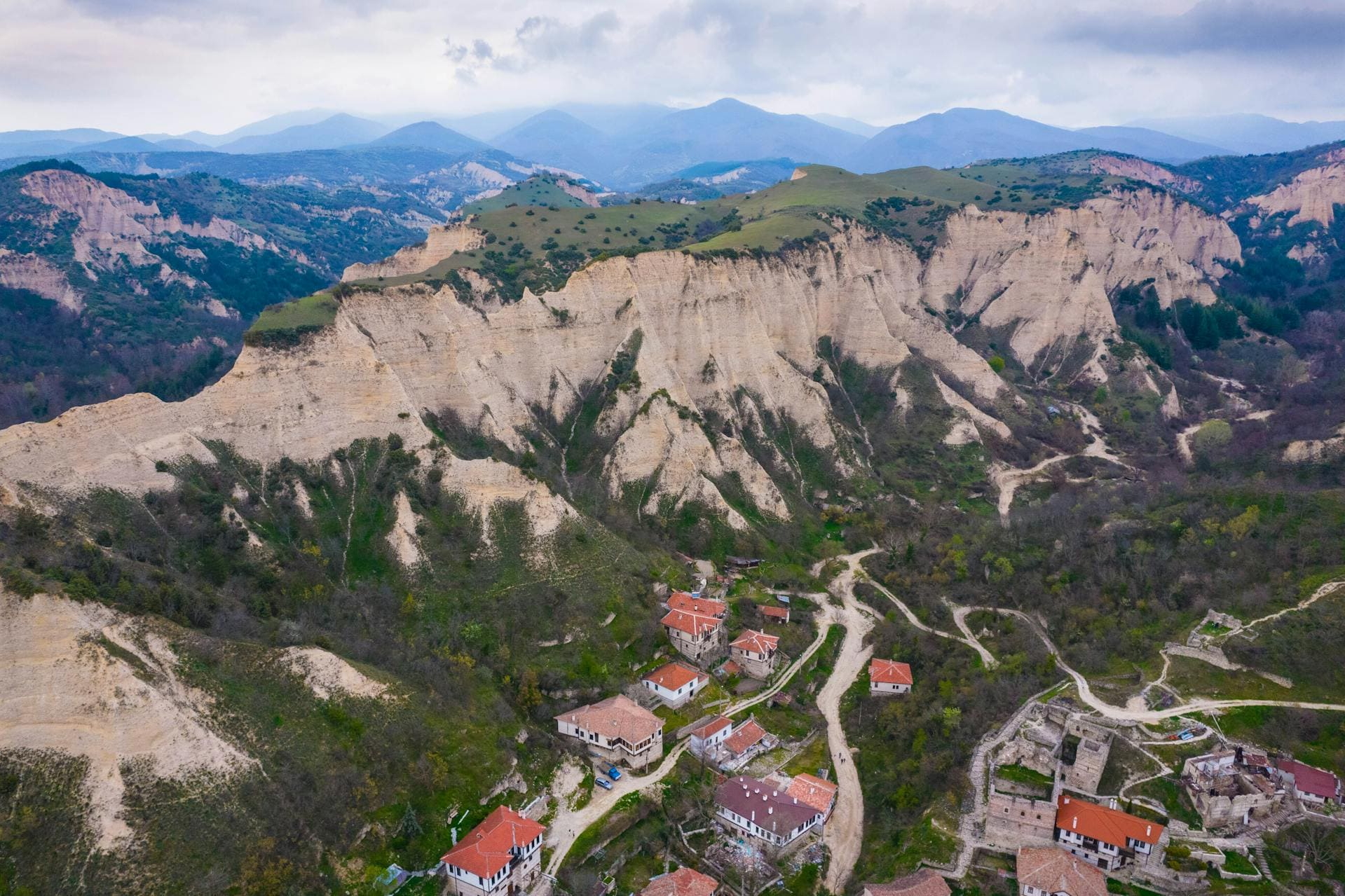 Blick auf Sandsteinfelsen und Dorf mit roten Dächern in Bulgarien