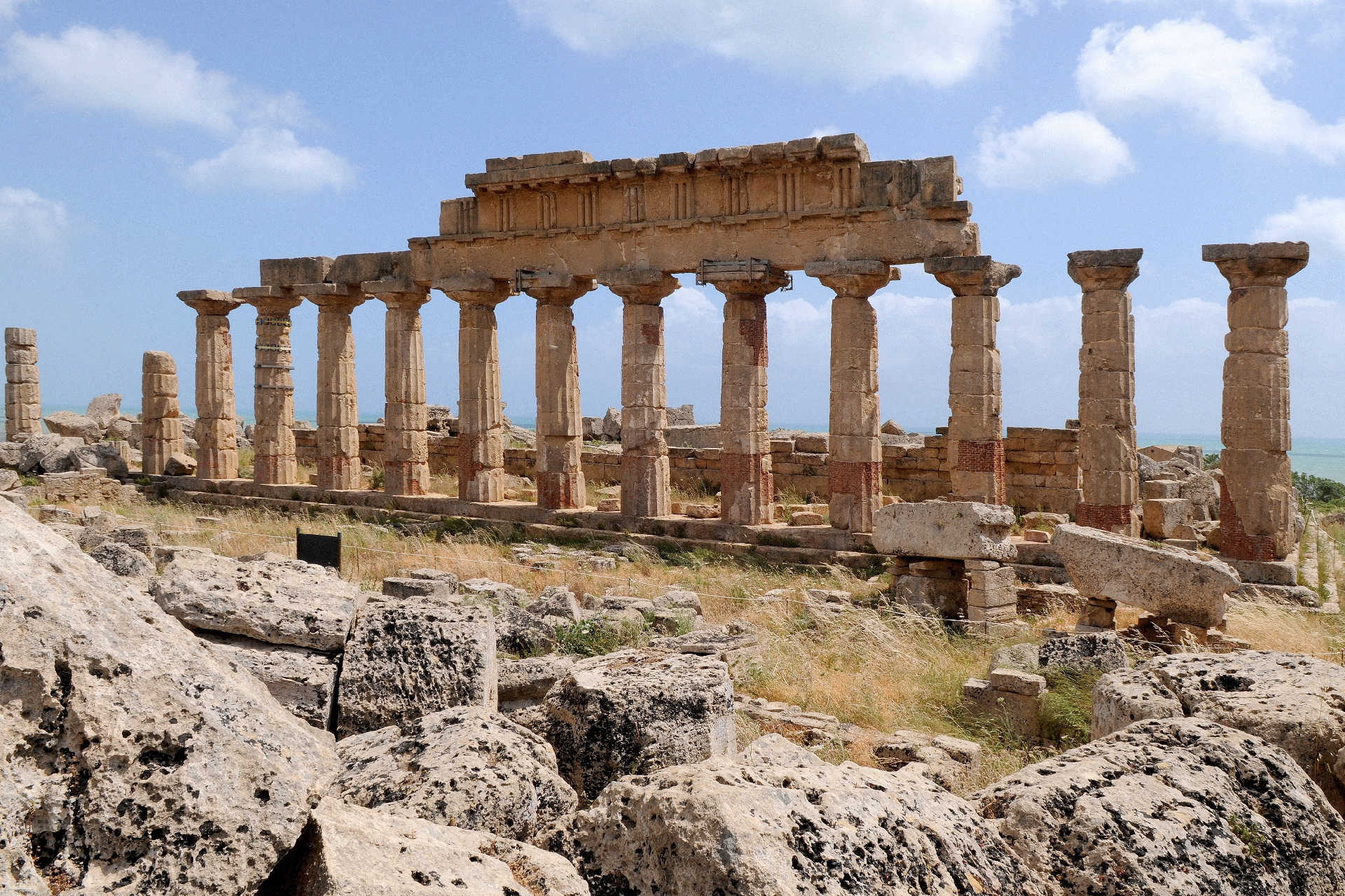 Antike Tempelruine mit erhaltenen Säulenreihen im archäologischen Park von Selinunt an der Südküste Siziliens, im Hintergrund das Meer.