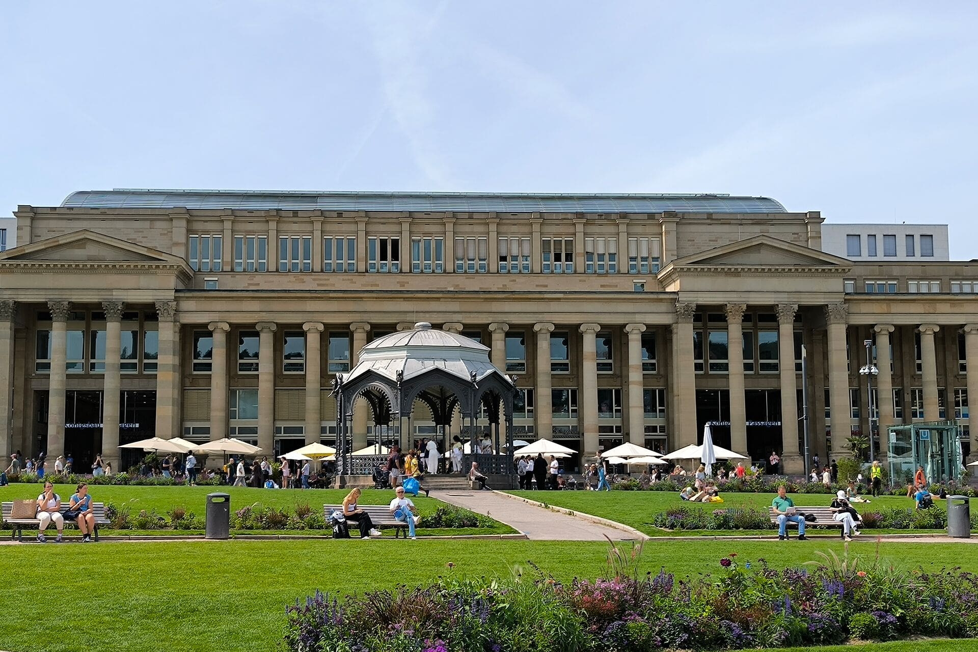 Historisches Säulengebäude mit Pavillon und Grünfläche davor