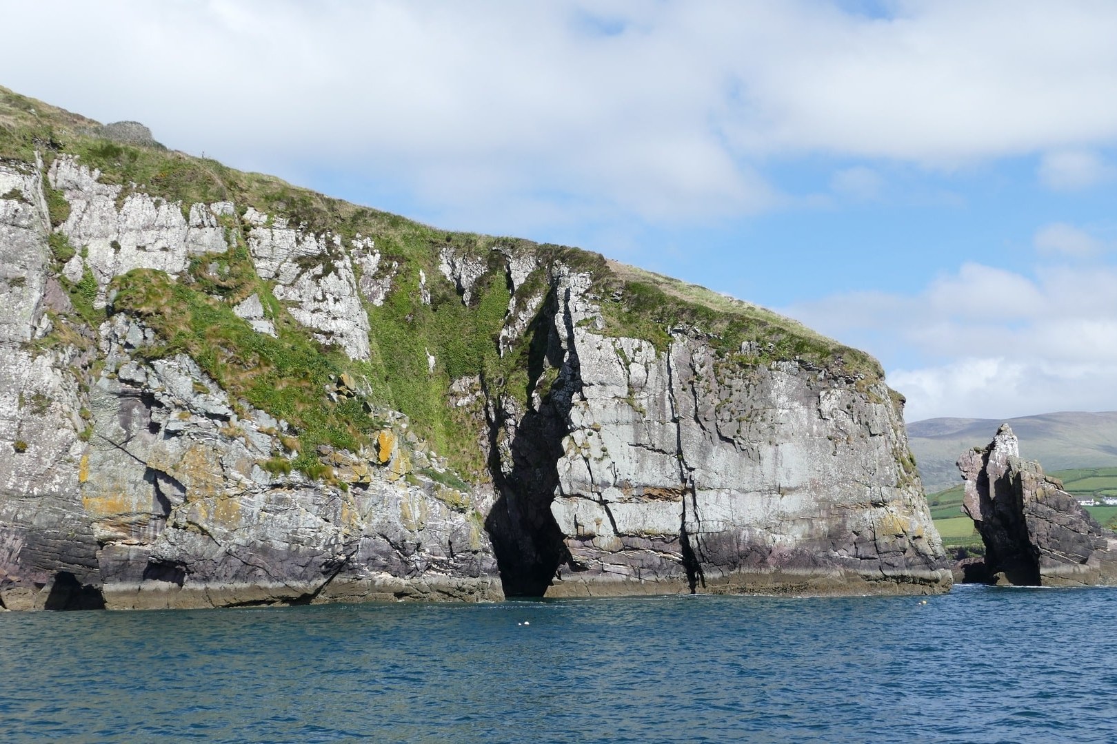 Steile Felsenküste mit markantem Felstor am Atlantik in Irland
