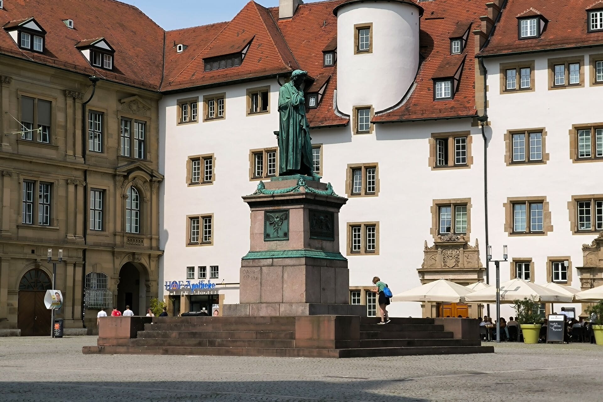 Bronzestatue von Friedrich Schiller vor historischen Gebäuden
