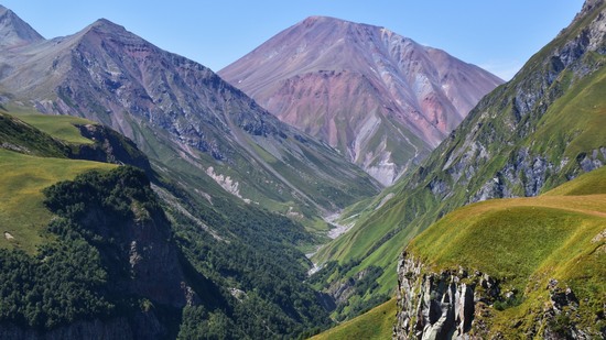 Grünes Tal führt hinauf zu farbig gestreiften Gipfeln im Gebirge