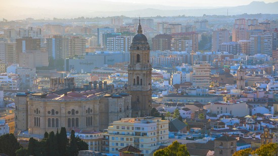 Blick über dicht bebaute Stadt mit markantem Kirchturm im Zentrum