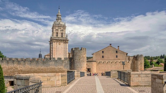 Steinerne Festungsmauer mit hohem Kirchturm und Toranlage