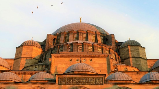 Große Kuppel mit kleineren Seitendächern leuchtet in warmem Licht